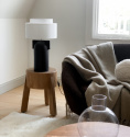 Bordslampan Figoll i svart i ett modernt vardagsrum med tr och jordnratoner