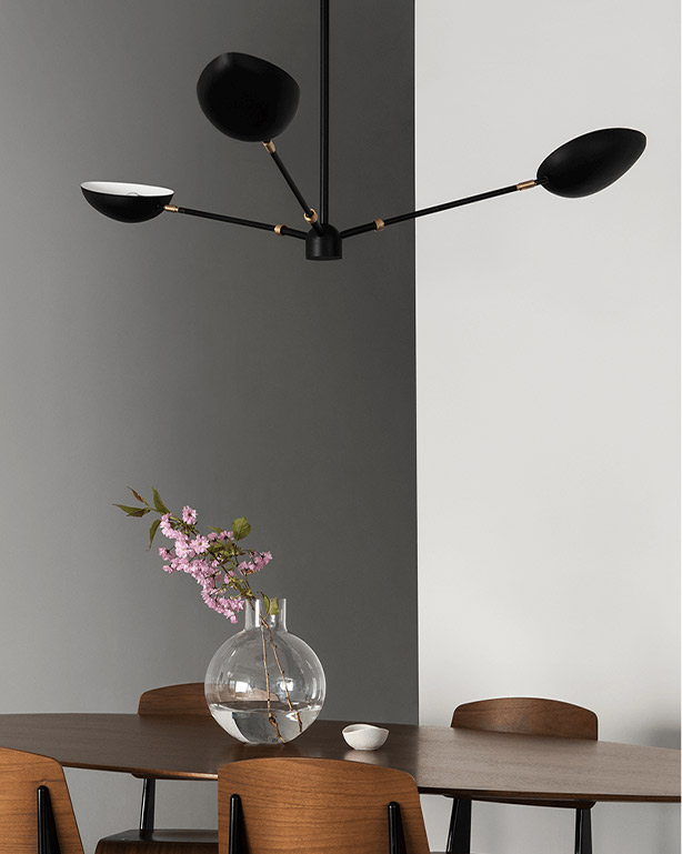 Den populära och snygga taklampan Spoon svart från watt och veke ovanför matbord och möbelgrupp i ek trä