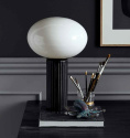 Opal Bordslampa på ett skrivbord, i ett svart vitt rum. Svart lampa med glas