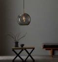 Design lampa i rkfrgat glas ovanfr ett litet bord i ett vardagsrum  