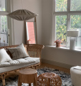 Franso taklampa i beige tyg i ett vardagsrum med rotting möbler. 