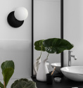 En svart snygg vgglampa Refa A bredvid spegeln i badrummet