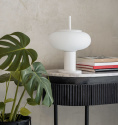 Snygg vit bordslampa p ett avlastningsbord i marmor och ribbat tr